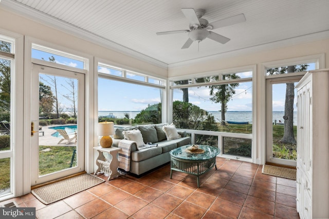 sunroom / solarium with a water view, a wealth of natural light, and ceiling fan