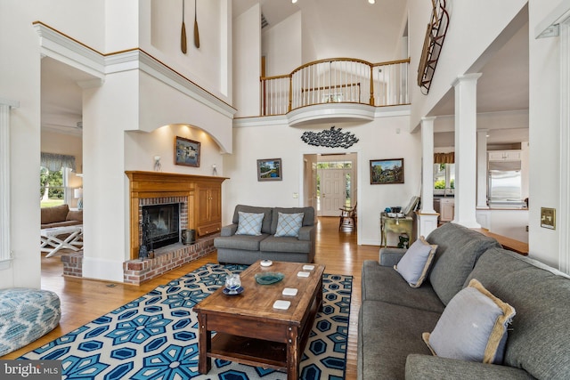 living room featuring ornate columns, a high ceiling, and a healthy amount of sunlight