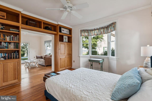 bedroom with wood-type flooring, crown molding, and ceiling fan