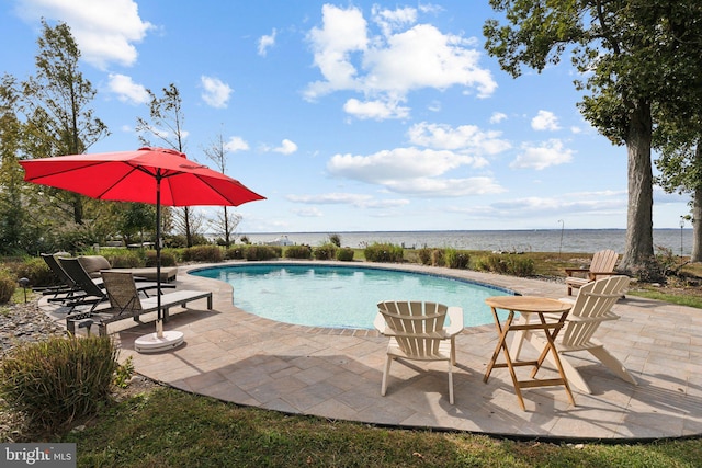 view of swimming pool featuring a water view and a patio area