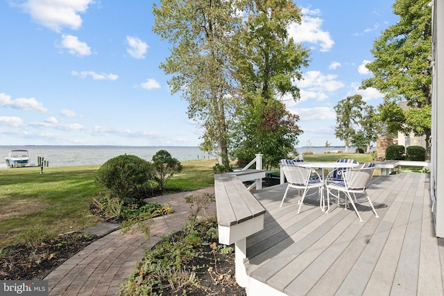 wooden terrace with a water view and a yard