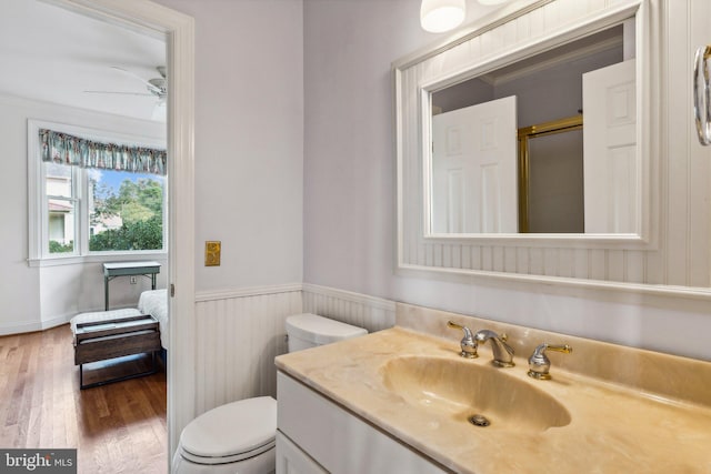 bathroom with walk in shower, toilet, crown molding, hardwood / wood-style floors, and vanity