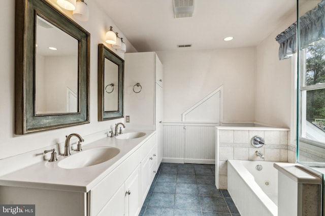 bathroom featuring vanity, plenty of natural light, tile patterned flooring, and a washtub