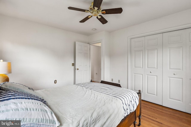 bedroom with a closet, hardwood / wood-style floors, and ceiling fan