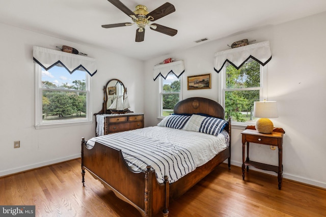 bedroom featuring light hardwood / wood-style floors, multiple windows, and ceiling fan