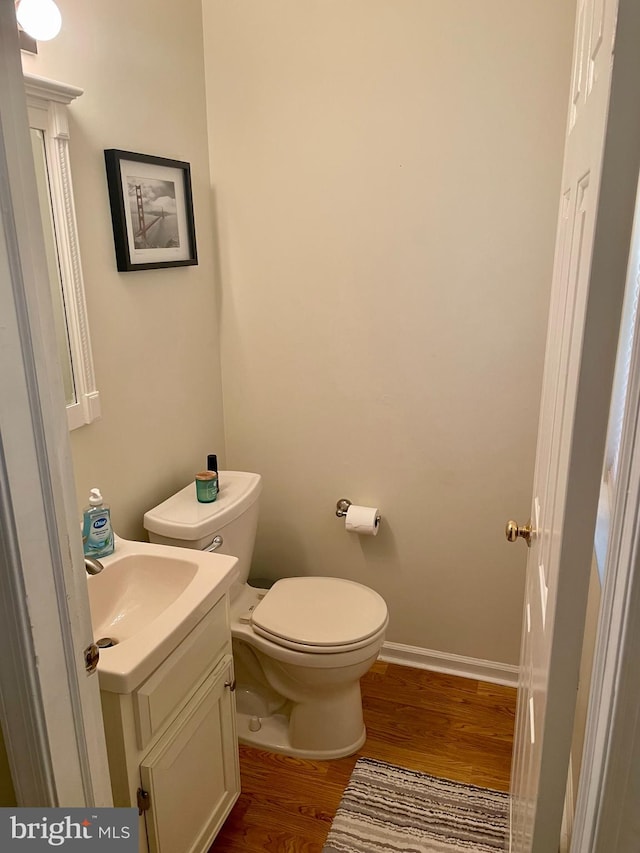 bathroom with vanity, toilet, and hardwood / wood-style floors