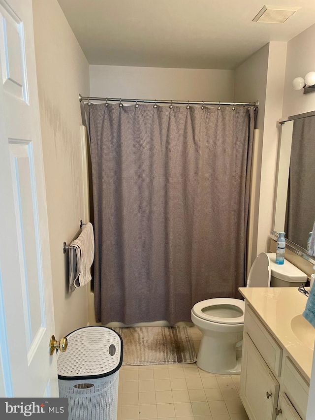 bathroom with walk in shower, vanity, toilet, and tile patterned floors