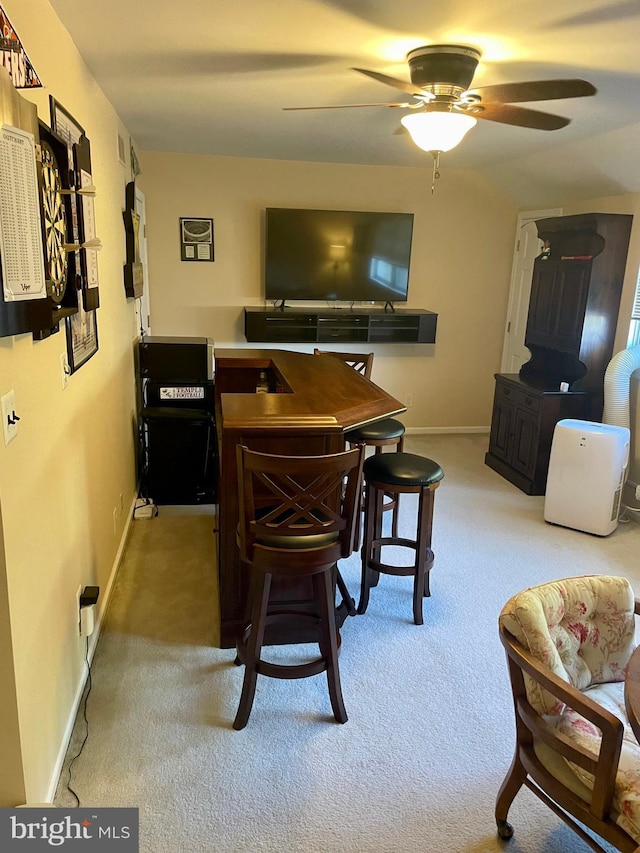 carpeted dining room with ceiling fan