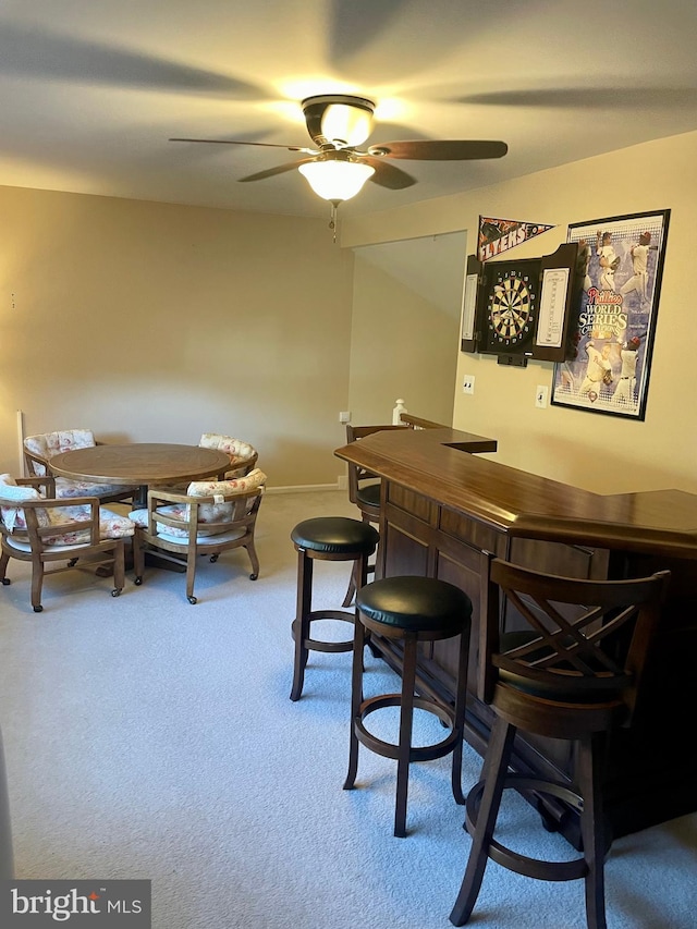 bar with ceiling fan and carpet floors