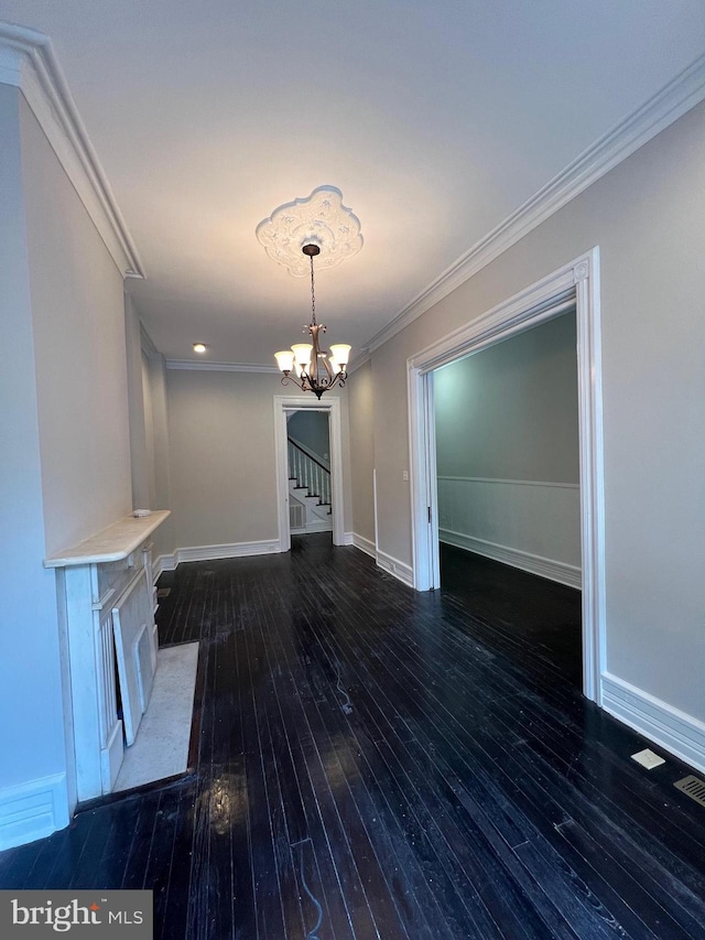 unfurnished living room with baseboards, a notable chandelier, ornamental molding, stairway, and hardwood / wood-style floors