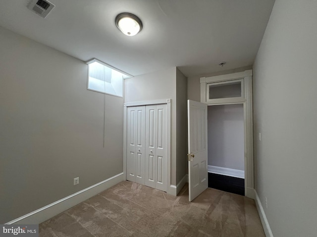 unfurnished bedroom with carpet, visible vents, a closet, and baseboards