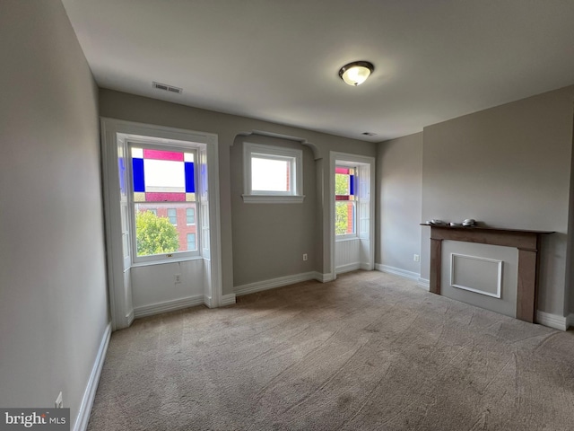 unfurnished living room featuring light colored carpet