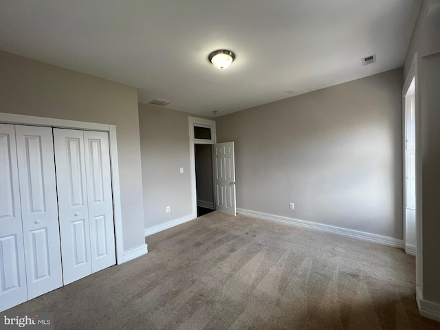 unfurnished bedroom featuring carpet flooring and a closet