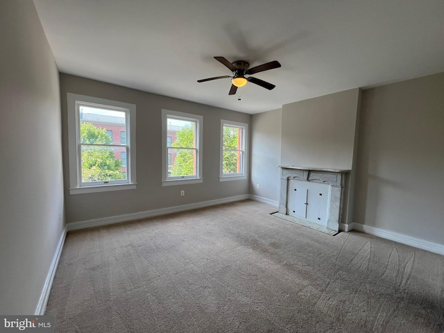 unfurnished living room featuring ceiling fan and light colored carpet