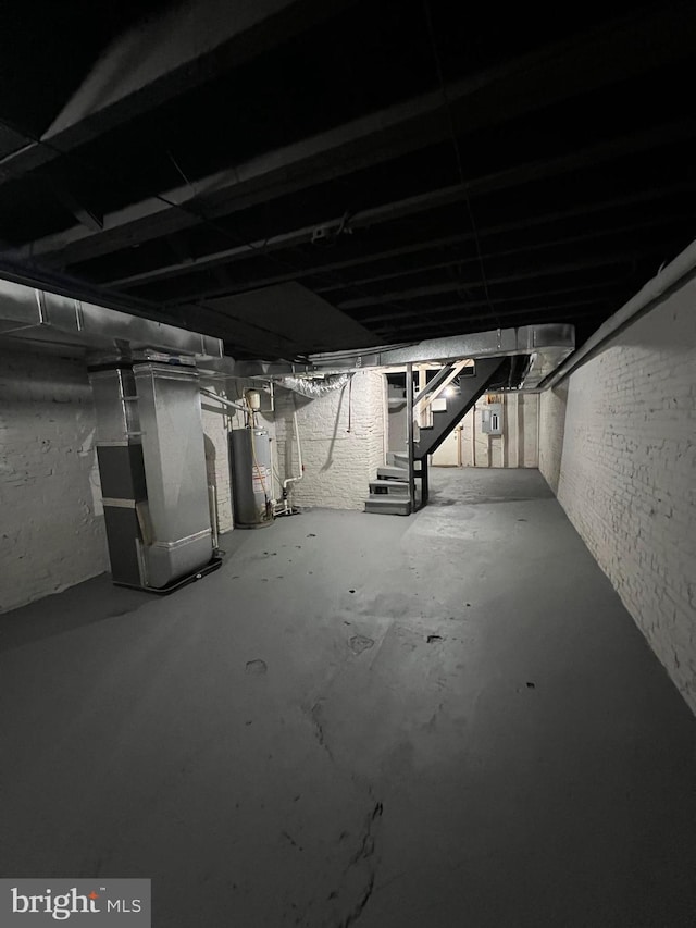 unfinished basement with stairway, heating unit, and gas water heater