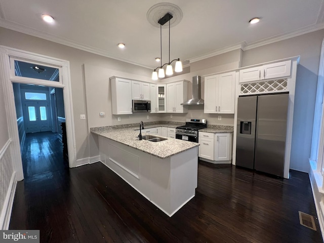 kitchen with pendant lighting, sink, white cabinetry, wall chimney range hood, and stainless steel appliances