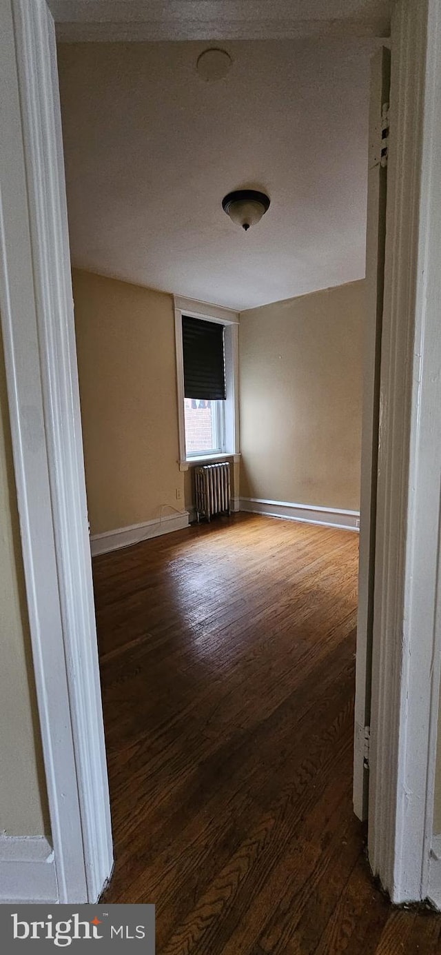 hallway with dark hardwood / wood-style floors and radiator