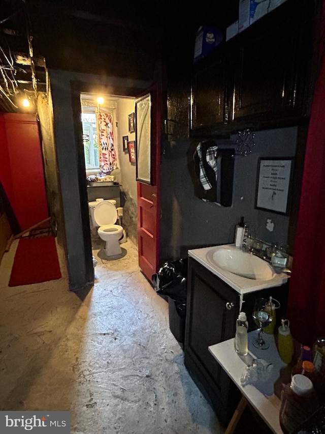 bathroom featuring vanity, toilet, and concrete floors