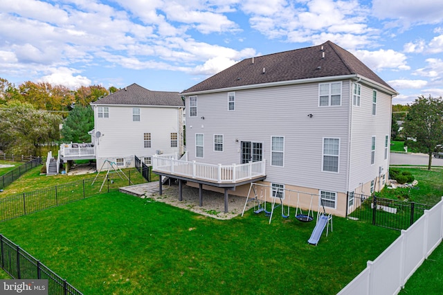 back of property with a wooden deck and a yard