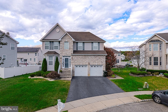 view of property featuring a garage and a front lawn