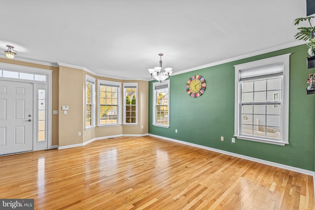 entryway featuring crown molding, a notable chandelier, and light hardwood / wood-style floors