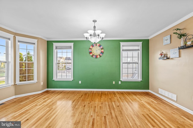 empty room with a chandelier, crown molding, and wood-type flooring