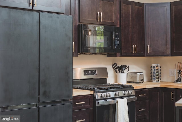 kitchen with refrigerator, dark brown cabinetry, stainless steel range with gas cooktop, and wood counters