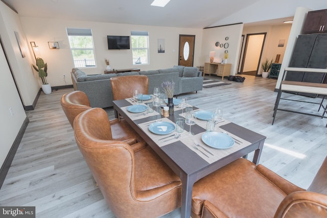 dining area with lofted ceiling and light wood-type flooring