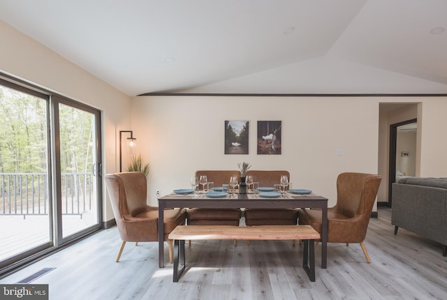 dining space with lofted ceiling and light wood-type flooring