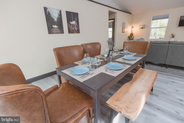 dining room with vaulted ceiling and light hardwood / wood-style flooring