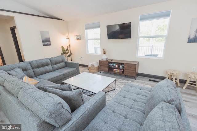 living room with light wood-type flooring and vaulted ceiling