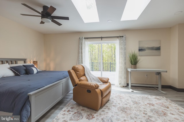 bedroom with ceiling fan, hardwood / wood-style flooring, and baseboard heating