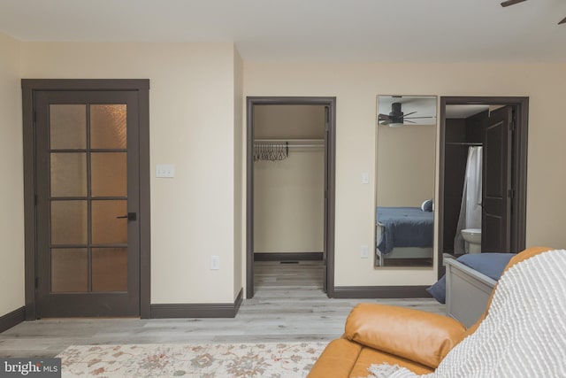 bedroom with ceiling fan, a closet, connected bathroom, and light hardwood / wood-style floors