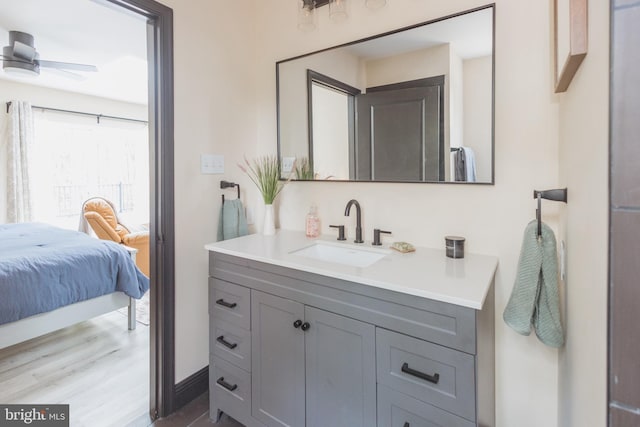 bathroom with wood-type flooring, vanity, and ceiling fan