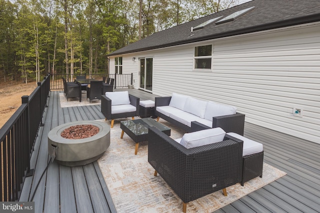 deck featuring an outdoor living space with a fire pit