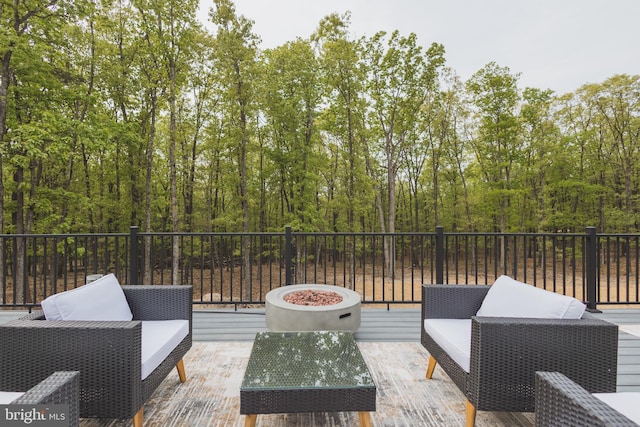 view of patio / terrace with a deck and an outdoor living space with a fire pit