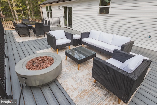 deck featuring an outdoor living space with a fire pit