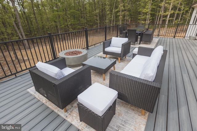 wooden terrace featuring an outdoor living space with a fire pit