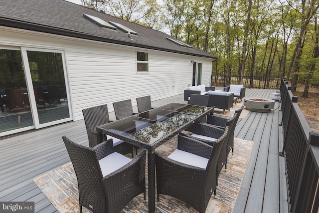 deck featuring an outdoor living space with a fire pit