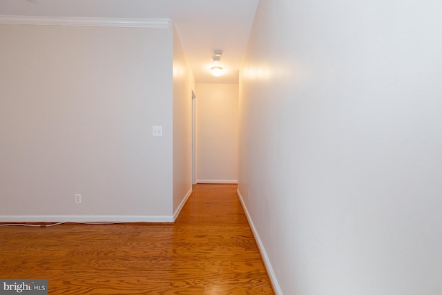 hall with ornamental molding and light hardwood / wood-style floors