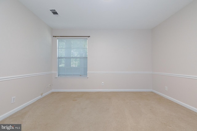 spare room featuring light carpet