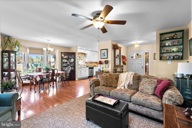 living room with light hardwood / wood-style flooring and ceiling fan with notable chandelier