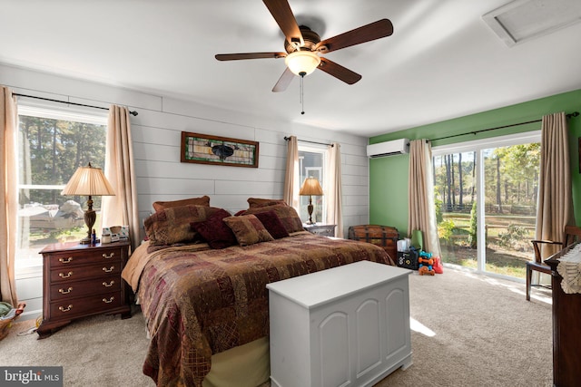 bedroom with a wall unit AC, multiple windows, light colored carpet, and ceiling fan