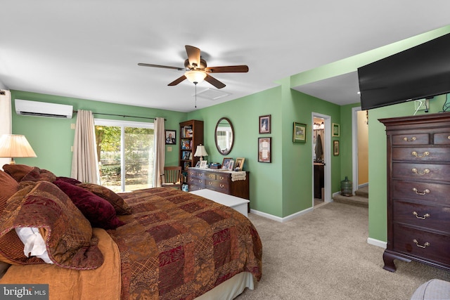 carpeted bedroom featuring a wall unit AC, ensuite bathroom, and ceiling fan