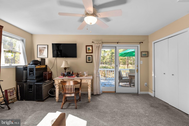 carpeted office space with ceiling fan and a healthy amount of sunlight