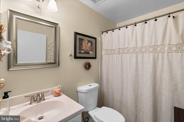 bathroom with toilet, curtained shower, and vanity