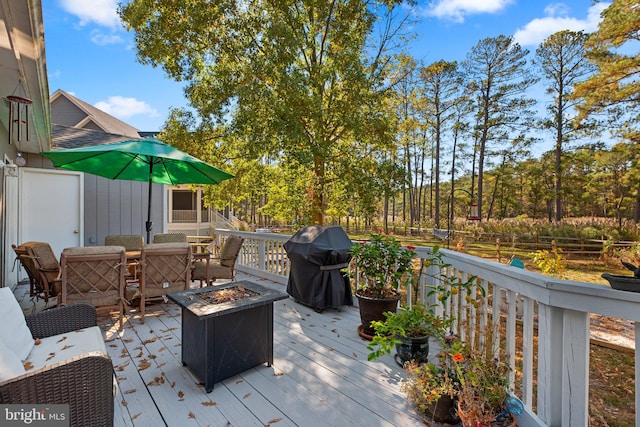 wooden deck with a grill and a fire pit