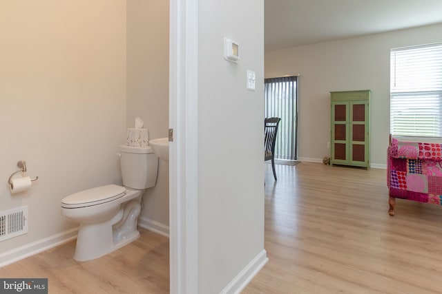 bathroom with hardwood / wood-style flooring and toilet