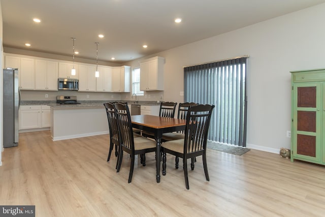 dining space featuring light hardwood / wood-style flooring and sink