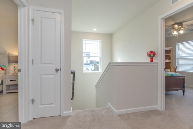 hall featuring light colored carpet